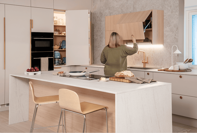 Moderni keittiö, vaalea puupintainen kaapisto, saareke ja keittiövälineet, kodin tunnelma.